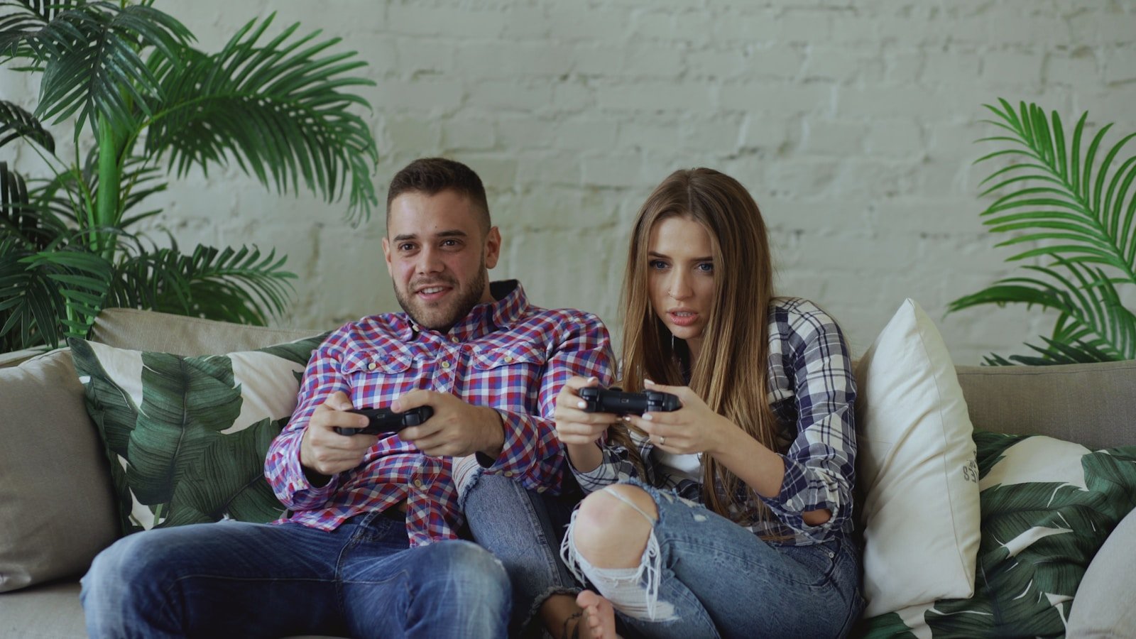 Couple playing video games on sofa